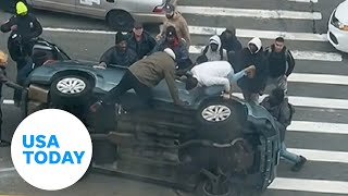 Good Samaritans New York City rush to help stuck driver flipped car  USA TODAY [upl. by Clea]