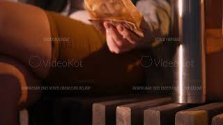 Closeup view of female hands taking thermos cup and putting fries on the bench [upl. by Puttergill]