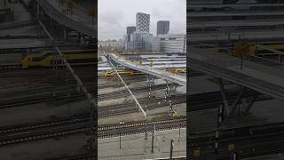 Wandel en fietsbrug met ijzerbomen over de sporen van het Centraal Station [upl. by Anam]