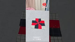 A red and black patchwork quilt square with a pinwheel design on a light gray background [upl. by Rici]