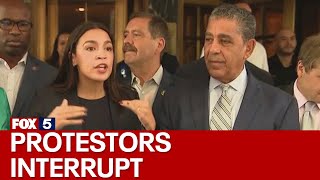 NYC migrant crisis AOC interrupted by protesters at Roosevelt Hotel [upl. by Asiak]