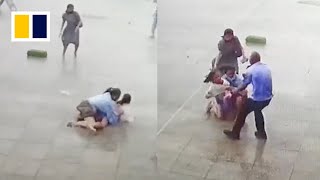 Security guard helps pedestrians knocked off feet in strong winds [upl. by Reynard]