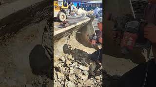 A worker uses a perforator to clean a loader bucket [upl. by Dranoc]